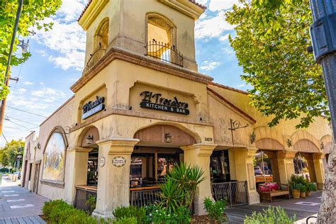 A Main Street corner restaurant with arched patio and awnings before the fire