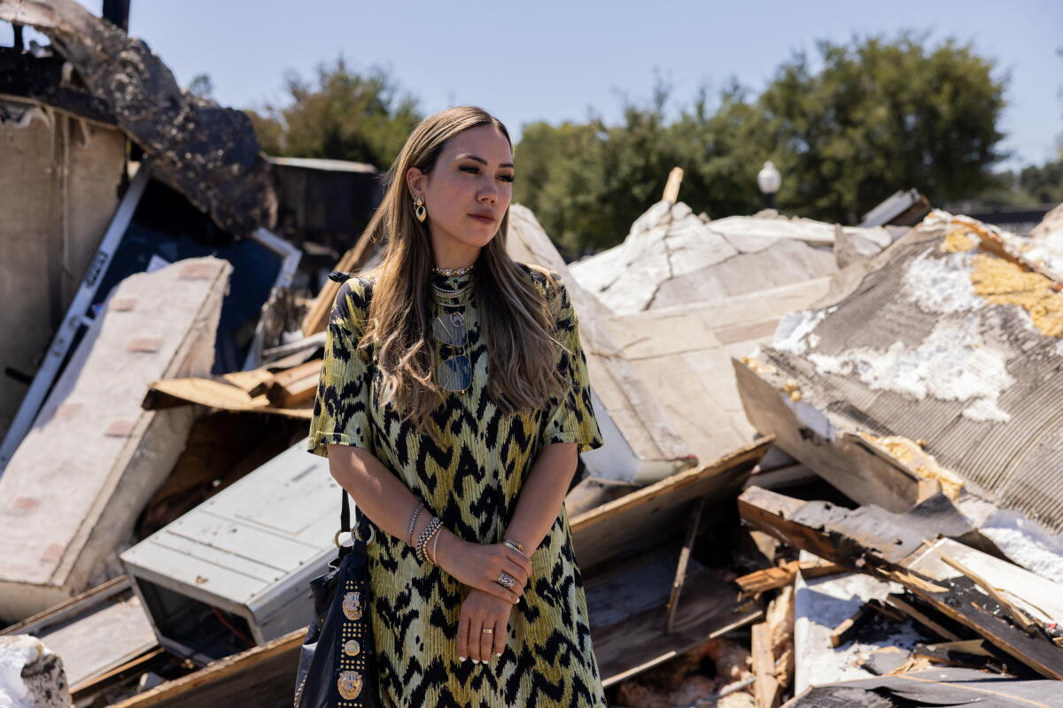A business owner standing in front of a pile of charred debris the morning after the fire
