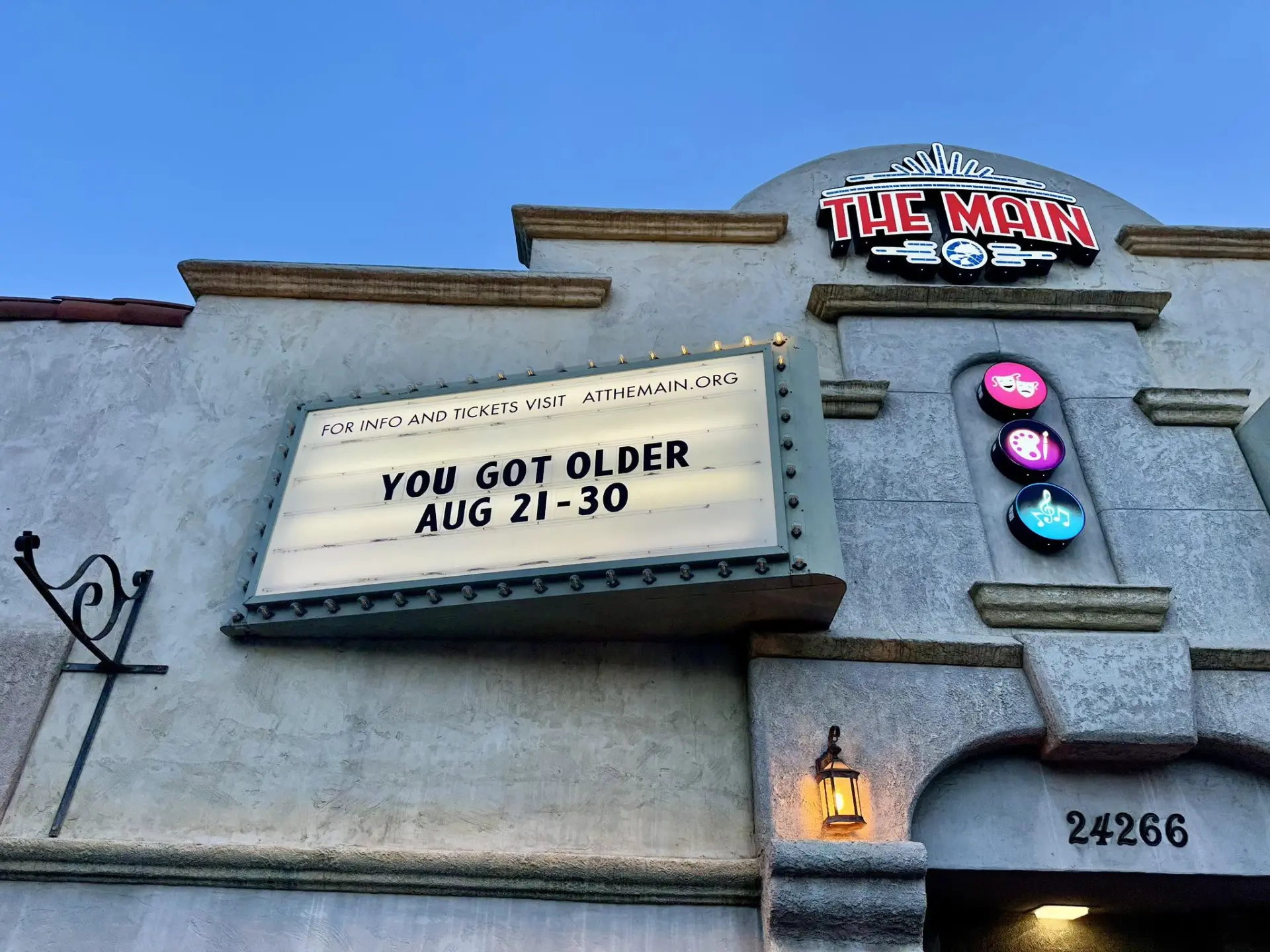 The Main theater marquee and neon sign at dusk before the fire