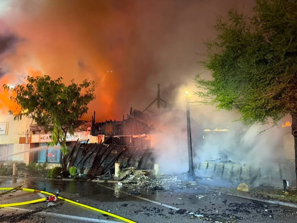 Firefighters spraying water on the collapsed, burning Main Street building at night